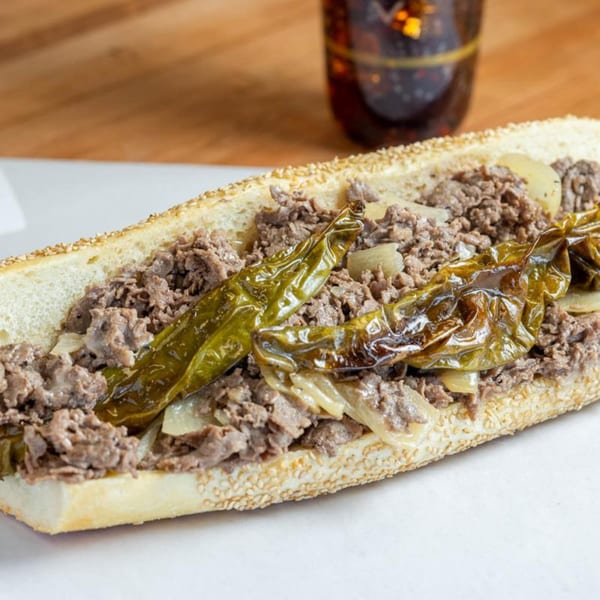 Ochinilis Steaks' cheesesteak with grilled onions and green peppers on a sesame seed roll.